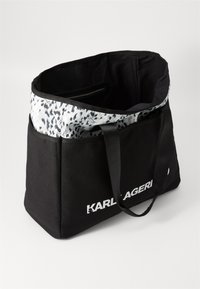 Svart canvas totebag med teksturert leopardmønstret interiør, utstyrt med to robuste håndtak og logoen "KARL LAGERFELD" i hvitt.