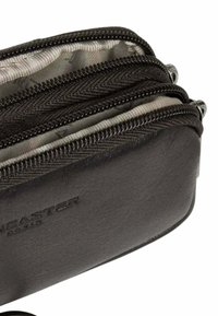 Portafoglio in pelle nera con molteplici scomparti con zip. L'interno è foderato con una trama grigia. Logo impresso all'esterno.