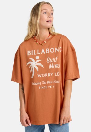 T-shirt oversize color ruggine in cotone, con grafica di palme bianche e design testuale. Maniche corte e vestibilità rilassata.