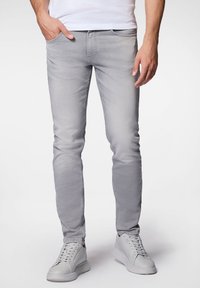Jasnoszare dżinsy o dopasowanym kroju, z klasycznym pięciopocketowym wzorem i delikatnym wyblaknięciem. W połączeniu z białymi trampkami.