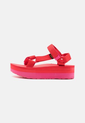 Sandale plateforme avec des brides rose vif et rouge et une semelle épaisse bicolore sur fond blanc.