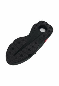Semelle de chaussure en caoutchouc noir avec des motifs de grip texturés, des indentations circulaires et une découpe circulaire centrale. Comprend un élément de marque.