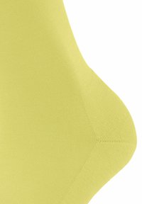 Żółty materiał o prążkowanej teksturze, z gładkim, zaokrąglonym brzegiem. Widoczne szwy wskazują na staranne szycie.