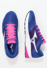 Des chaussures de sport bleues présentent une tige en mesh avec des lacets et des accents roses, une semelle intermédiaire blanche et une semelle extérieure en caoutchouc noir avec une adhérence texturée.