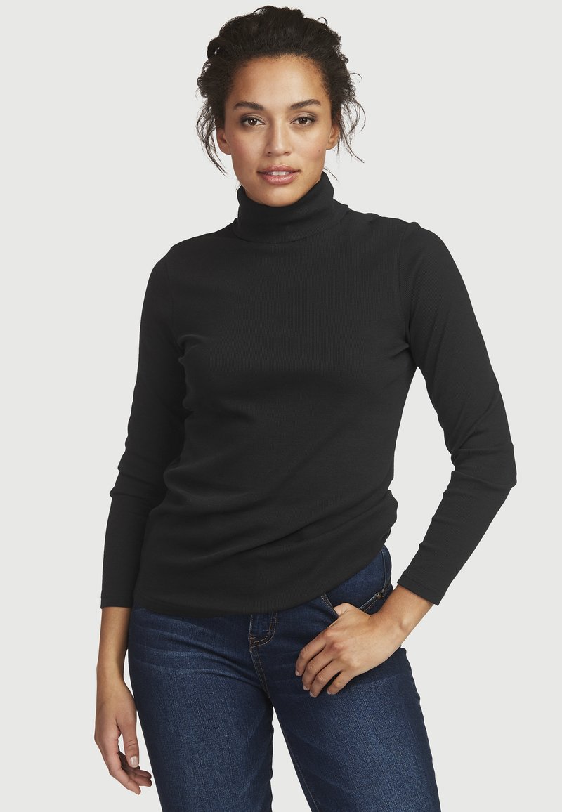 Black turtleneck top in ribbed fabric with long sleeves, paired with blue jeans. Features a fitted silhouette and subtle texture.