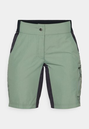 Helles grünes Shorts mit einem schwarzen Bund und seitlichen Einsätzen. Zu den Merkmalen gehören genähte Nähte und eine Cargotasche am rechten Bein.
