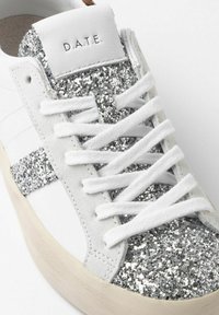 Hvide sneakers med glitrende sølvdetaljer, blød ruskindsoverflade og hvide snørebånd. Logoet "D.A.T.E." præget på hæltab.