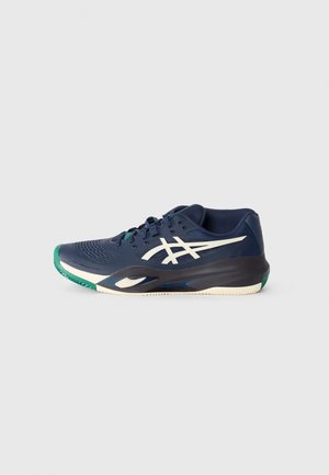 Scarpa sportiva blu navy con tomaia testurizzata, logo bianco e dettagli verdi sulla punta e sulla suola. Presenta una soletta imbottita per un supporto ottimale.
