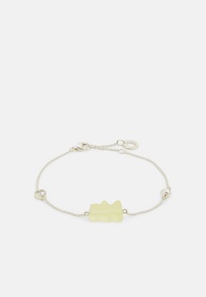 Sidabrinė grandinėlė su šviesiai geltonu, tekstūruotu centru, turinčiu banguotą dizainą, akcentuota maža perla ir apvaliu užsegimu.