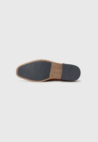 Shoe sole with a brown rubber base and dark blue textured section, featuring a flat shape and subtle grooves for traction.