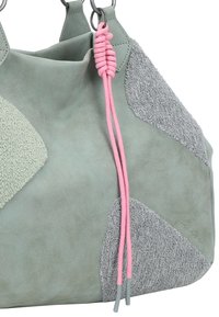 Un sac en cuir vert avec des accents en daim gris, une finition texturée et un cordon de serrage noué rose.