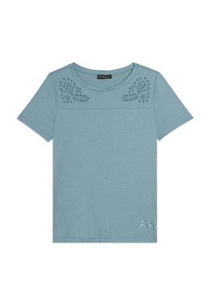 Camisa de manga corta azul claro con cuello redondo, patrones florales recortados en la parte superior delantera y pequeño logo blanco "Freddy" en la parte inferior derecha.