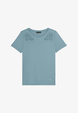 Camisa de manga corta azul claro con cuello redondo, patrones florales recortados en la parte superior delantera y pequeño logo blanco "Freddy" en la parte inferior derecha.