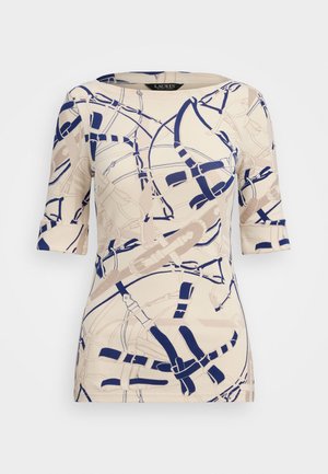 Tejfehér blúz rövid ujjakkal, tengerészkék és bézs absztrakt mintával, amely hevedereket és hurkokat idéz. Simább anyagtextúra, kerek nyakú.