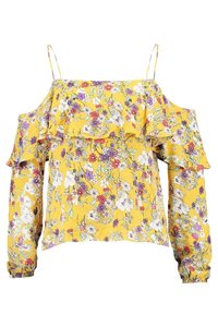 Blusa floreale gialla con design off-shoulder, accenti arricciati, maniche lunghe e un tessuto leggero e morbido con motivi floreali multicolori.