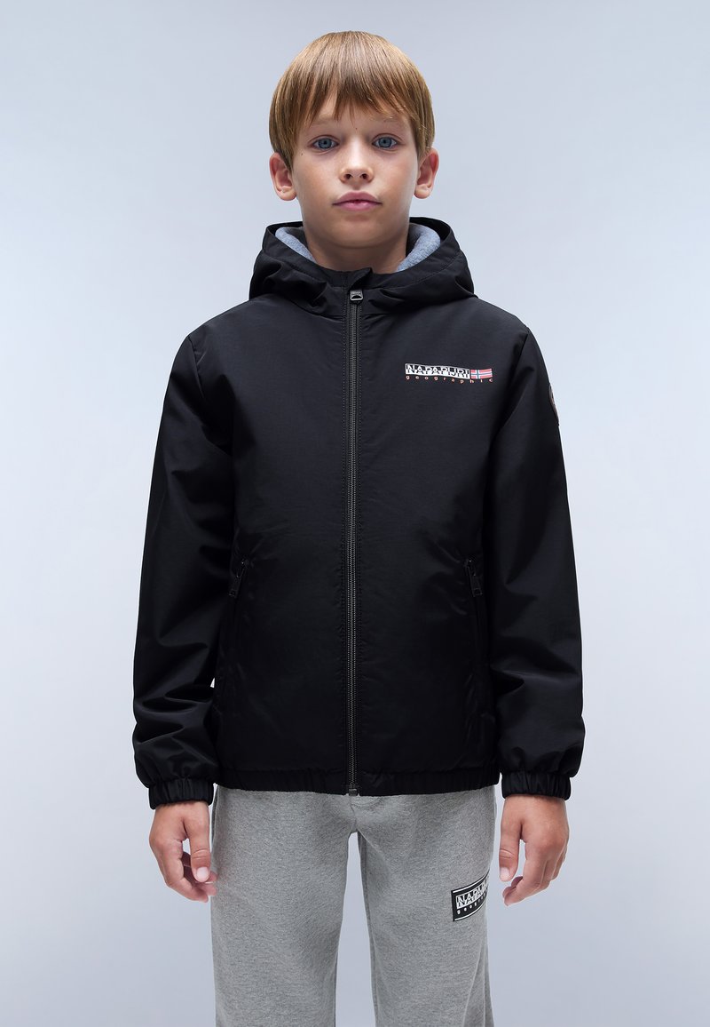 Black hooded jacket with a zip front, elastic cuffs, logo on the chest, and gray lining. Worn over light gray sweatpants.