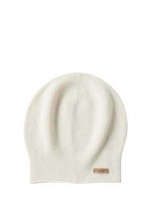 Cappello a maglia color crema con texture liscia, forma arrotondata e una piccola targhetta in pelle con logo sul bordo.