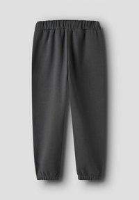 Donkergrijze joggingbroek met elastische tailleband en boorden, plat gelegd op een lichtgrijze achtergrond.