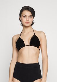 Svart virkat bikiniöverdel med triangulära kupor, såsom med scalloped kanter och tunna justerbara axelremmar. Högmidjade texturerade svarta underdelar.