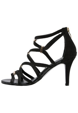 Black suede high-heeled sandal with multiple crisscross straps and golden accents, featuring a pointed toe and a slim stiletto heel.