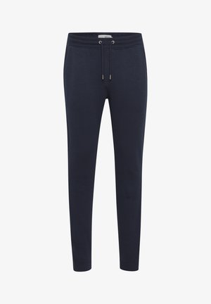 Navy joggerit, jotka on valmistettu pehmeästä kankaasta, eväät elastinen vyötärönyöri, kapenevat lahkeet ja ribbineulelahkeet nilkoissa.