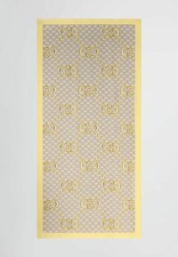 Tejido beige con un patrón que presenta un diseño de logotipo repetido en amarillo, bordeado por un borde amarillo brillante, con una textura suave.