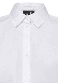 Hvid skjorte med knapper, der har en klassisk krave, fem knapper og et diskret broderet "A|X"-logo på venstre bryst. Glat tekstur.