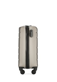 Harde koffer in lichtgrijs met horizontale ribbelstructuur, zwarte rits, vergrendelmechanisme en vier zwarte wielen voor mobiliteit.