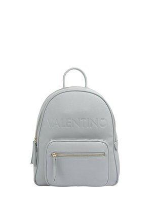 Zaino in pelle grigia chiara con forma arrotondata, caratterizzato da un logo impresso, una tasca frontale con zip e manico superiore. Accenti in hardware dorato.