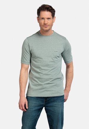 T-shirt vert à manches courtes avec un col rond et un détail de poche, en tissu doux, associé à un jean bleu.