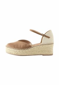 Wedge espadrillas in suede color marrone con punta rotonda, suola intermedia in juta intrecciata e retro in tessuto intrecciato. Cinturino regolabile alla caviglia per una vestibilità perfetta.