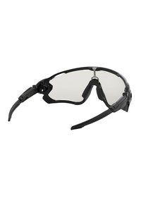 Occhiali da sole sportivi neri con un design elegante, naselli regolabili e lenti trasparenti. Presentano aste flessibili per comfort e vestibilità.