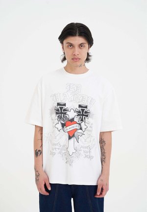 Witte katoenen t-shirt met oversized pasvorm, voorzien van zwarte kruisgraphics en een rood hart gelabeld "LOS ANGELES" aan de voorkant. Casual ontwerp.