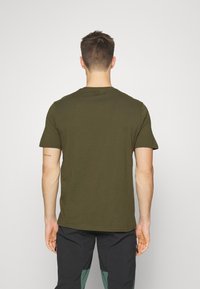 Oliven grøn bomulds T-shirt med rund halsudskæring og korte ærmer, med et enkelt design, lige kant og minimale detaljer.