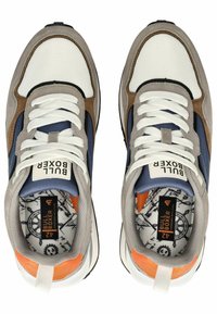 Grijze en witte sport sneakers met een bovenwerk van gaas, suède accenten in bruin en blauw, witte veters en een oranje hiel detail.
