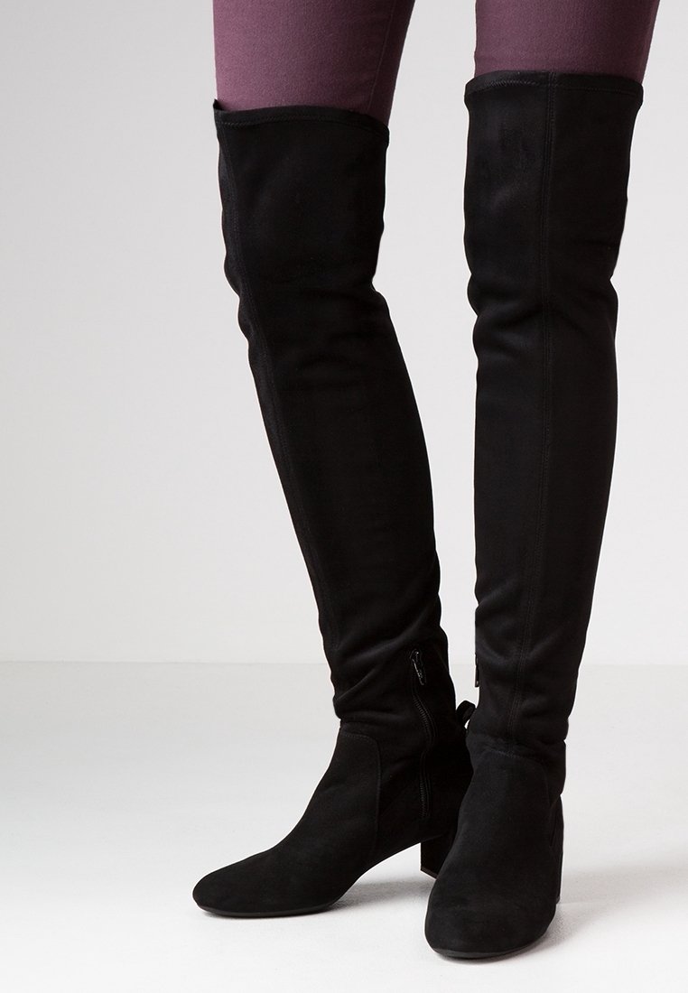 Black over-the-knee boots made of soft suede. Chunky heel, fitted design with zipper detail on the inside, smooth texture.