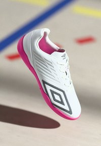 Biele atletické tenisky s ružovou podrážkou, s textúrovaným zvrškom, sieťovinovými vložkami a čiernym diamantovým vzorom. Šnurovanie v tradičnom štýle.