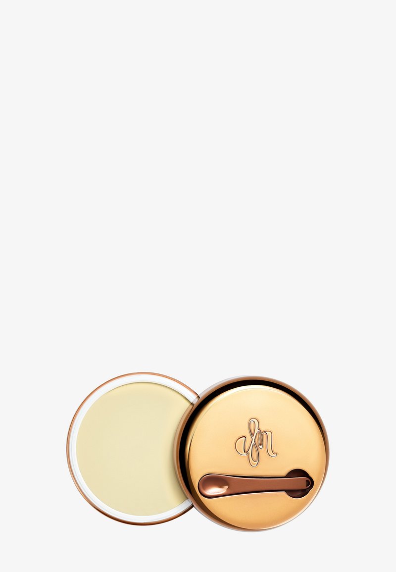 Gullmetallbeholder med rund form, med en bronse spak og preget logo. Lokket er åpnet for å avsløre en lys gul balsam inni.