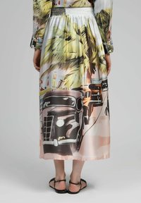 Jupe longue et soyeuse avec un motif tropical représentant des palmiers et des voitures vintage. Texture lisse, taille élastique et palette de couleurs pastel.