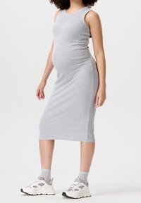 Robe midi grise côtelée sans manches, coupe près du corps, texture lisse, associée à des baskets blanches épaisses et des chaussettes gris clair.