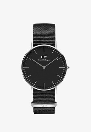 Orologio analogico nero con cassa rotonda in acciaio inossidabile, quadrante nero, indicatori argentati e cinturino in nylon intrecciato nero con un anello metallico.