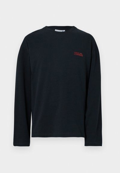 Fekete, hosszú ujjú póló, puha anyagból készült, amelyen egy kicsi piros logó található a bal mellen, kerek nyakkivágással és egyenes aljjal.