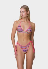 Costume da bagno a bikini con reggiseno a triangolo e slip con lacci. Realizzato in tessuto a righe colorate con accenti rosa e motivi giocosi.