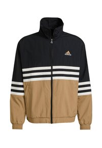 Črna, peščena in bela vetrovka z visokim ovratnikom, polnim zadrgo spredaj, belimi črtami na rokavih in adidas logotipom na prsih.