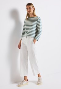 Gestreepte blauw-witte longsleeve top, witte brede broek en beige sneakers met roze accenten. Eenvoudig ontwerp, casual stijl.