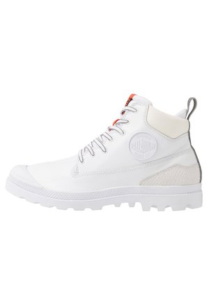 Biały, wysokie buty Palladium z przodu na sznurowadła, z poduszką przy kostce, teksturowaną łatką na pięcie i wytrzymałą podeszwą, pokazane z boku.