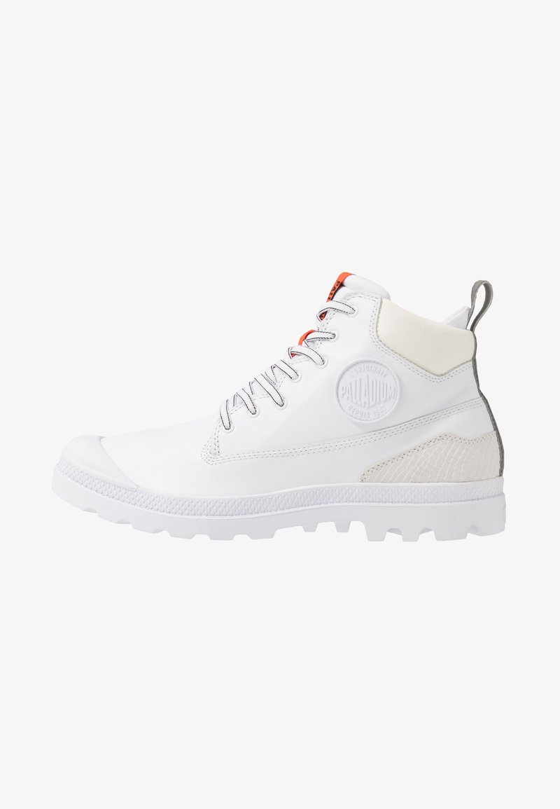 Botte montante blanche Palladium avec fermeture à lacets à l'avant, col de cheville rembourré, patch texturé au talon et semelle robuste, vue de profil.