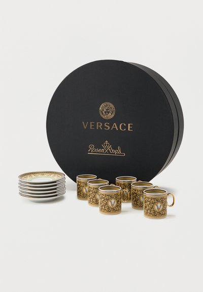 Σετ έξι περίτεχνα χρυσά και μαύρα φλιτζάνια εσπρέσο με αντίστοιχα πιατάκια, τοποθετημένα μπροστά σε μαύρο στρογγυλό κουτί Versace Rosenthal.