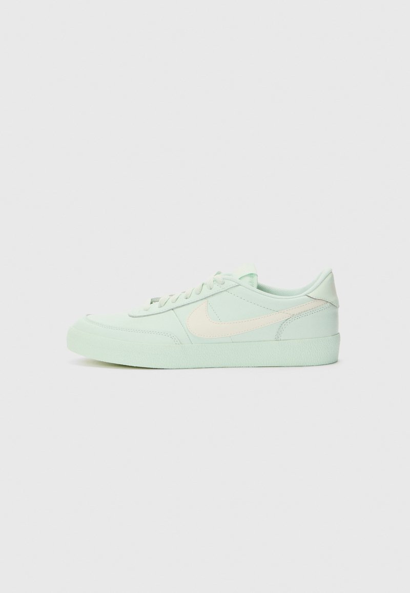 Baskets vert clair avec une tige texturée, dotées d'un swoosh couleur crème, de lacets plats et d'une semelle en caoutchouc. Dessus arrondi et design à profil bas.