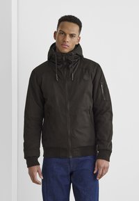 Dunkelbraune Kapuzenjacke mit Reißverschluss vorne, gerippten Bündchen und zwei Seitentaschen, mit einem kleinen Logo auf der Brust und strukturiertem Stoff.